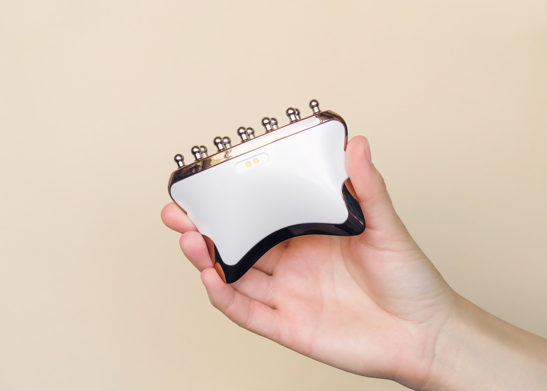 Hand Holding A Modern Microcurrent Skincare Device for Facial Rejuvenation